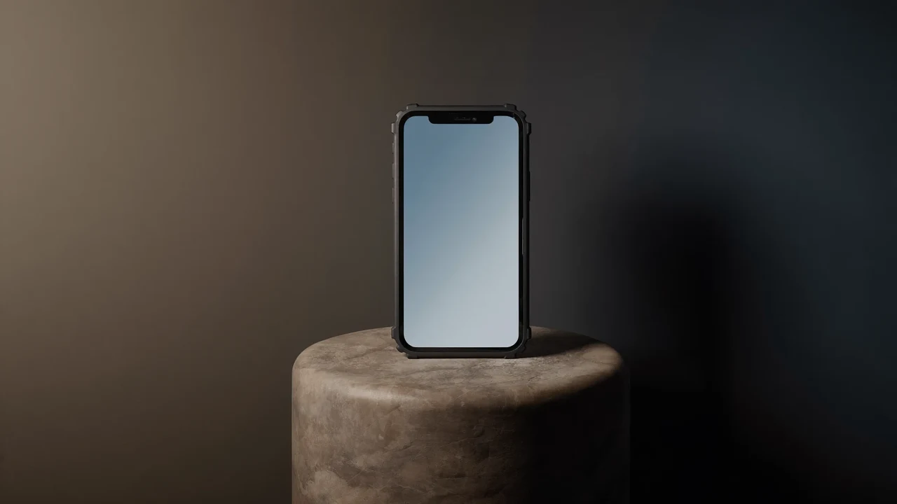 Telefon i robust mørkt cover på en stenpiedestal i blødt sidelys
